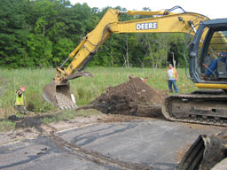 The new culvert gets packed with sewer rocks.